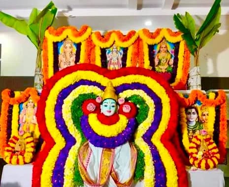 Home shrine with deity idols and flower alankara